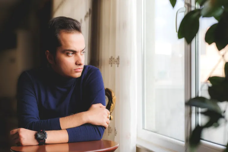 Person in thoughtful reflection symbolizing recovery from Alcohol Use Disorder